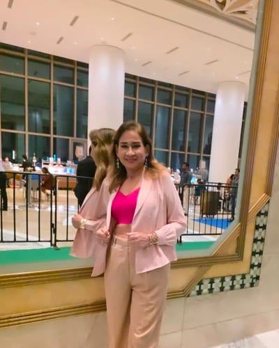 Professional woman in a hotel wearing a formal jacket endorsing Beepops protein bars as a healthy, snackable, complete protein source